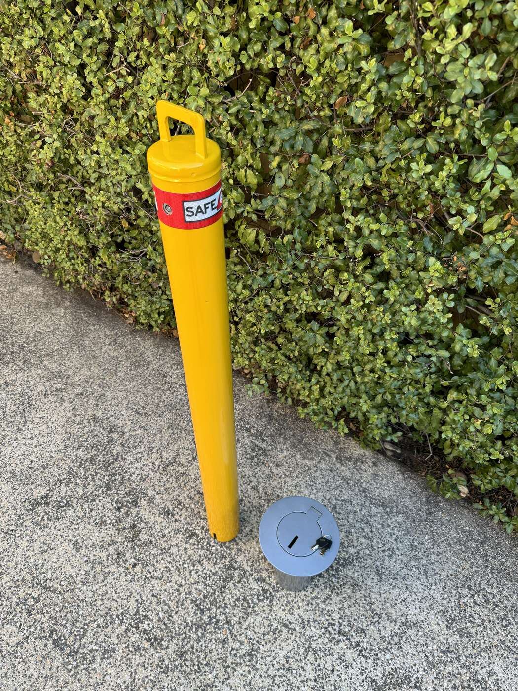 SafeWise removable key-lock safety bollard lifted out beside its in-ground socket