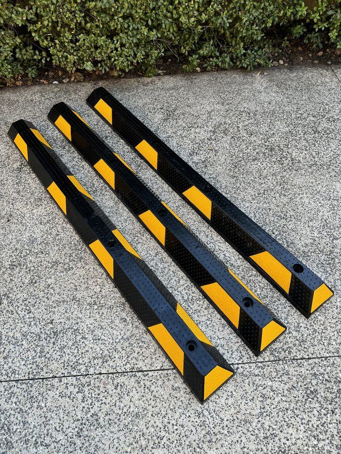 Rubber wheel stop close-up showing moulded fixing holes